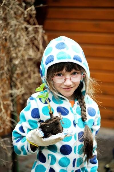 Happy little girl planting sprouts — Stock Photo, Image