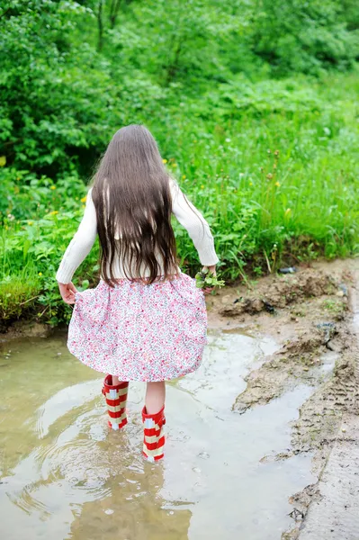 Elegancki dziecko dziewczynę stojącą w kałuży — Zdjęcie stockowe