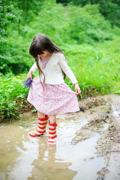 Elegant barn flicka stående i en vattenpöl — Stockfoto