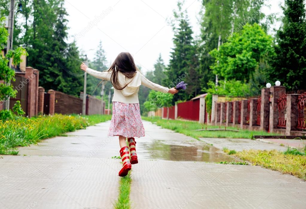 Elegant child girl walking on a rainy day