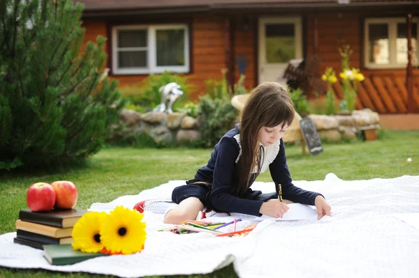 Cute schoolgirl in navy uniform drawing a picture — Stock Photo, Image