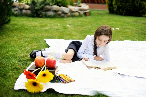 Linda chica en uniforme escolar leyendo un libro —  Fotos de Stock