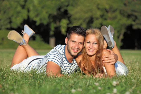 Linda pareja joven acostada en la hierba —  Fotos de Stock