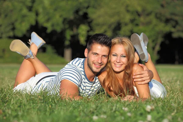 Mignon jeune couple couché dans l'herbe Images De Stock Libres De Droits