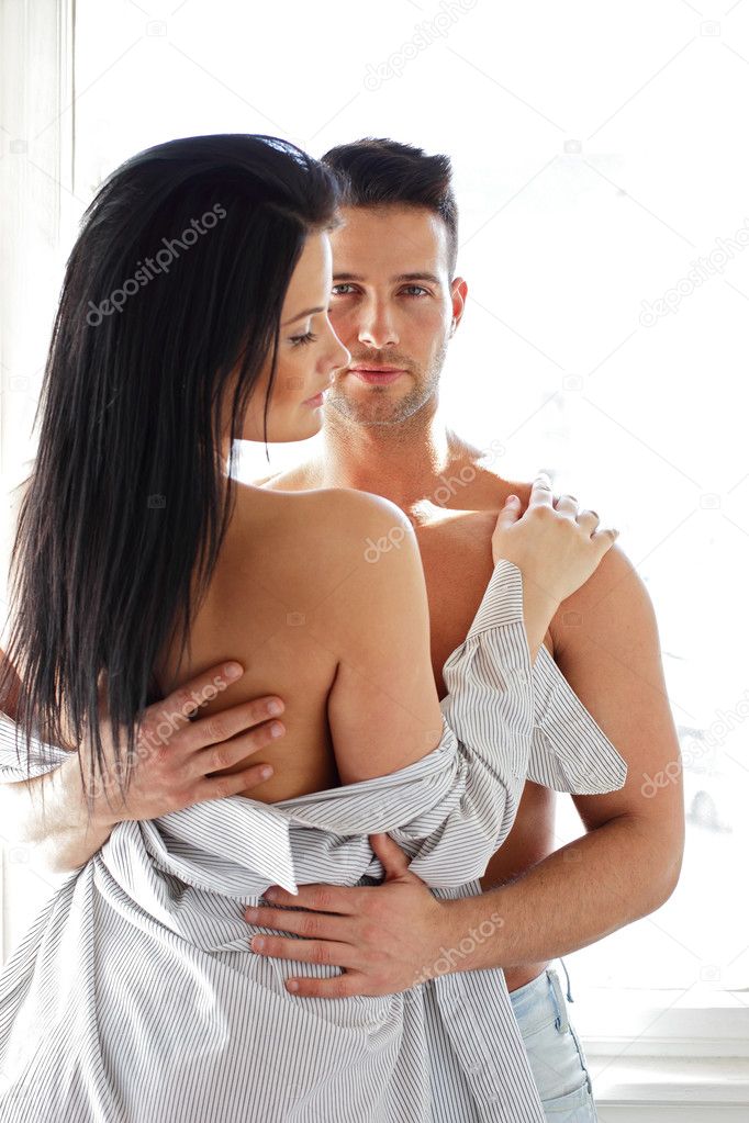 Man hugging his half naked girlfriend