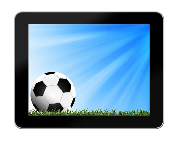 Футбол в зеленой траве с фоном в tablet-pc — стоковое фото