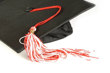 Beyaz bir arkaplanda mezuniyet şapkasının yakın çekimi..