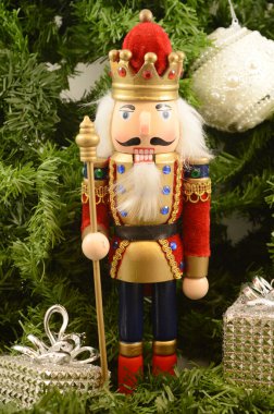 Bir Kral Noel Fındıkkıranı tatil sezonunda çam ağacının yaprakları arasında sevinçle oturur..