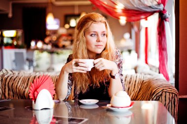 A young woman having lunch at a cafe laughing
