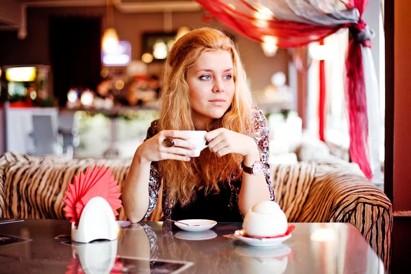 Uma jovem mulher almoçando em um café rindo — Fotografia de Stock