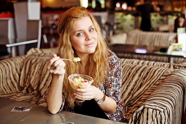 Una joven almorzando en un café riendo Fotos de stock