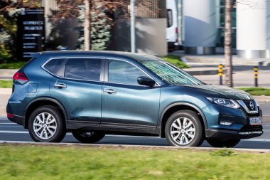 Moskova; Rusya - 14 Ekim 2021: Mavi Nissan X-Patikası sıcak bir sonbahar gününde bir parkın arka planına doğru hızla ilerliyor