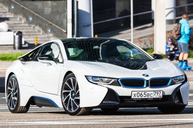 Moskova, Rusya - 13 Ekim 2021: Beyaz BMW i8, sıcak bir sonbahar gününde bir binanın arka planına park edilmiştir.