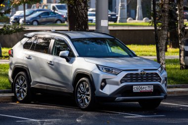 Moskova, Rusya - 13 Ekim 2021: Gümüş renkli Toyota RAV-4 sıcak bir sonbahar gününde bir parkın arka planına park edilmiştir.