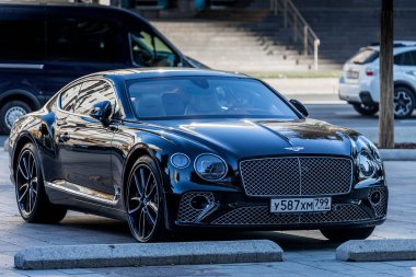 Moskova, Rusya - 13 Ekim 2021: Siyah Bentley Continental GT, sıcak bir sonbahar gününde bir binanın arka planına karşı sokağa park edilmiştir.