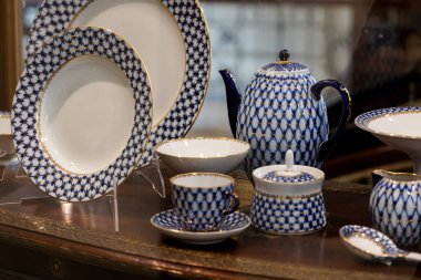 Tabaktan yemek servisi, kahve demliği, şeker kasesi, çay çiftleri, vitrindeki sümük tenceresi.