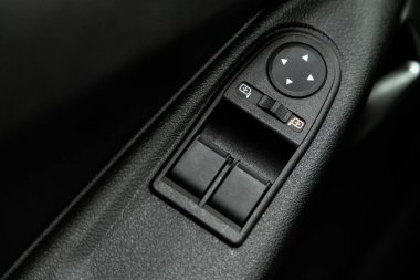 Yeni arabadaki bir kapı kontrol paneline yakın çekim. Pencere kontrol paneli, kapı kilidi düğmesi ve ayna kontrollü kol dinlenmesi.