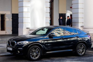 Moskova; Rusya - 15 Ekim 2021: Siyah BMW X6, sıcak bir sonbahar gününde bir binanın arka planına park edilmiştir.