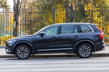 Moskova; Rusya - 15 Ekim 2021: Siyah Volvo XC90, sıcak bir günde sonbahar parkının arka planına park edilmiştir. 