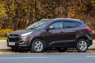 Moskova; Rusya - 15 Ekim 2021: Kahverengi Hyundai ix35, sıcak bir günde sonbahar parkının arka planına park edilmiştir. 