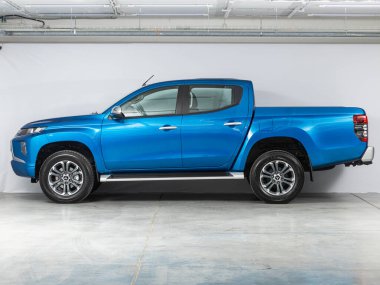 Novosibirsk, Rusya - 24 Ekim 2021: mavi Mitsubishi L200, yan görüş. Park yerinde büyük bir kamyonet var.  