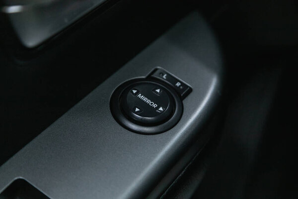 Novosibirsk, Russia - November 18, 2021:  Kia Rio, Car door interior armrest with window control panel, door lock button. Interior details.