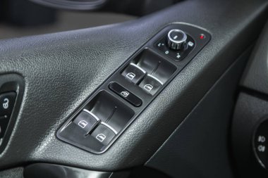 Novosibirsk, Russia - December 01, 2021:   Volkswagen Tiguan, Car door interior armrest with window control panel, door lock button. Interior details