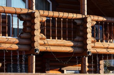 Close-up wooden balcony of a country house decorated with christmas garlands