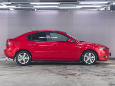 Novosibirsk, Russia - December    09 , 2021: red Mazda 3, side view.  Photography of a modern sedan  made in Japan on a parking in Novosibirsk