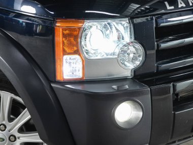 Novosibirsk, Russia - January    11 , 2022:  Land Rover Discovery,  Close up of the car headlights. Exterior closeup detail