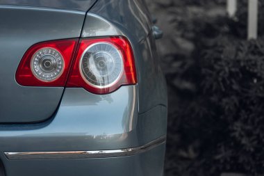 Mavi bir sedan arabanın arkası: tampon, bagaj kapağı, arka beyaz arka planda stop lambası. Reklam endüstrisi için hazırlan. Yeni araba konsepti