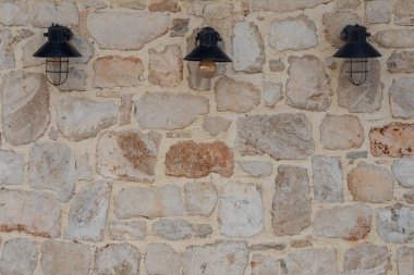 Taş bir duvarda güzel sokak lambaları. Eski kalenin taş duvarının arka plan dokusu.