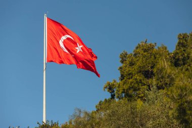 Mavi gökyüzüne doğru dalgalanan bayrak direğinde Türkiye 'nin ulusal bayrağı