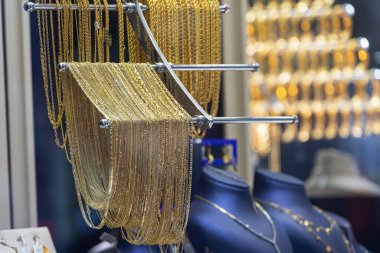 Kuyumcu vitrininde altın bilezikler, zincirler var.,