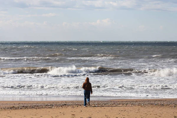 Kvinnan Går Längs Stranden Och Tittar Det Rastlösa Djuphavet Lugn — Stockfoto