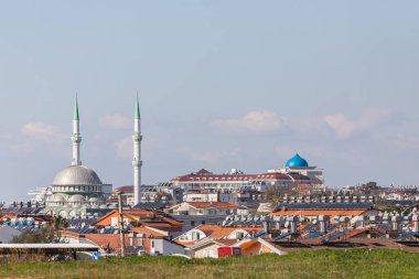 Alçak evleri, çatısı ve güneş panelleri, şehir camisi ve otelleri olan renkli Türk sokakları 