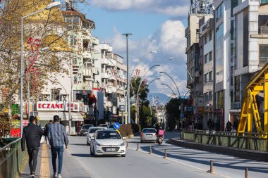 Manavgat, Türkiye - 20 Ocak 2022: Düşük katlı farklı caddeler, nehir üzerinde sarı köprü ve aktif araba trafiği, dükkanlar