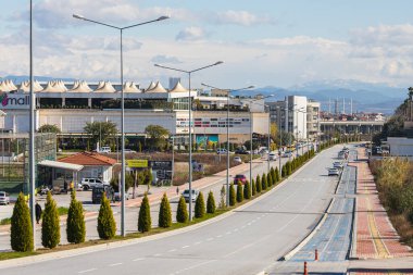 Yana, Türkiye - 23 Ocak 2022: Temiz ve özgür bir şehir caddesi. Düşük katlı evler, büyük Nova alışveriş merkezleri, arka planda arabalar ve dağ olan şehir sokakları. 