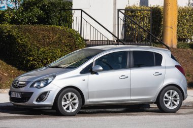Yana, Türkiye - 22 Ocak 2022: Gümüş Opel Corsa, sıcak bir günde bir çitin arka planına, bahçeye park etti.