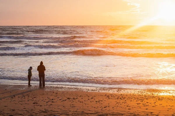 ママと息子は写真を撮って 美しい地平線で海の上の夕日をお楽しみください 自然の不思議 冬の海の美しい風景 — ストック写真