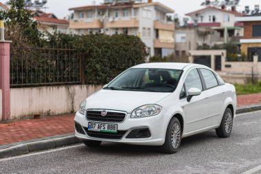 Yan, Türkiye - 25 Ocak 2022: Beyaz Fiat Linea, sıcak bir yaz gününde sokağa park edilmiştir.
