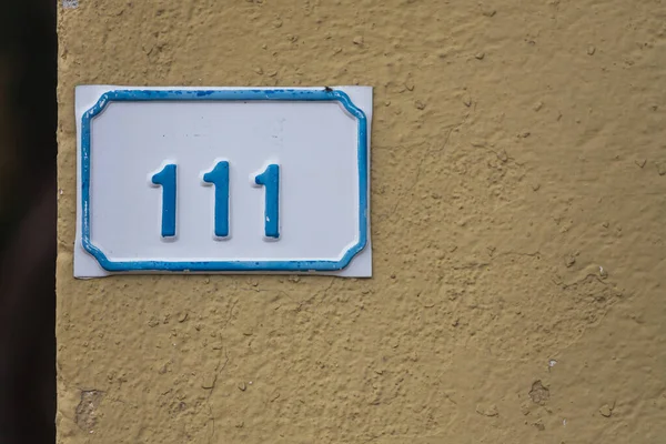 Zbliżenie Białej Niebieskiej Tablicy Numerem 111 Starym Żółtym Domu — Zdjęcie stockowe