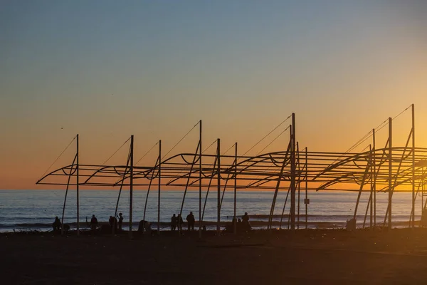 Группа Людей Убирает Мусор Пляжа Наслаждается Закатом Над Морем Красивым — стоковое фото