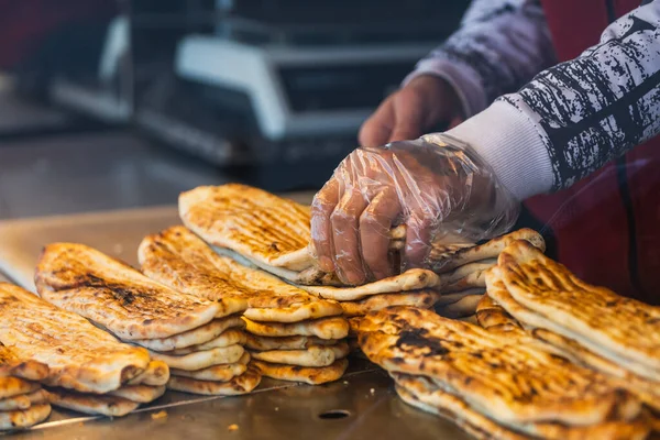 Eldivenler hazırlayan yakın plan erkek aşçı, profesyonel bir mutfakta pide.
