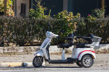 Yana, Türkiye - 27 Ocak 2022: Kargo sepetli küçük şehir motosikleti bir yaz günü caddeye park ediyor.