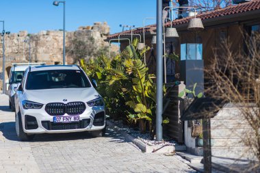Yana, Türkiye - 27 Ocak 2022: Beyaz BMW X1 bir yaz günü tarihi bir merkezin arka planına karşı sokağa park ediyor