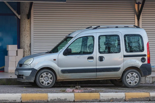 Yana, Türkiye - 27 Ocak 2022: Gümüş Renault Kangoo bir yaz günü bir binanın, dükkanın arka planına karşı sokağa park ediyor