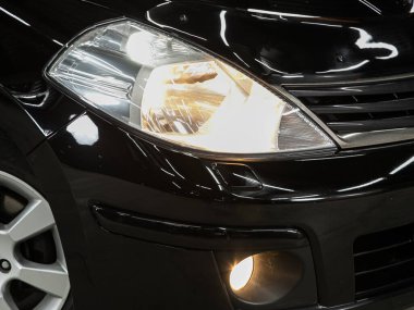 Novosibirsk, Rusya - 08 Şubat 2022: Nissan Tiida, modern popüler bir arabanın far ışığı. Işıktan parlayan parlak cam araba farları.
