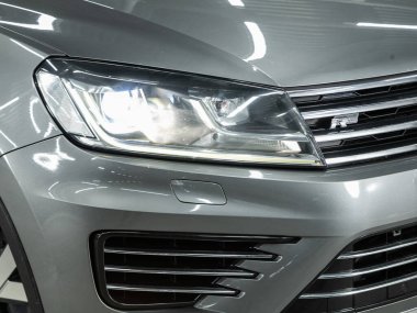 Novosibirsk, Rusya - 08 Şubat 2022: Volkswagen Toureg, modern popüler bir arabanın far ışığı. Işıktan parlayan parlak cam araba farları.