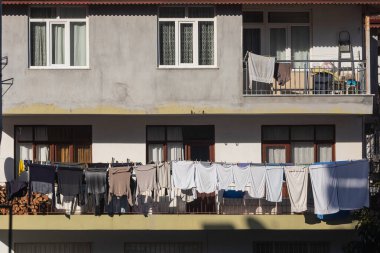 Türk şehrinde gri bir ev, çamaşırları ipte kuruyor.